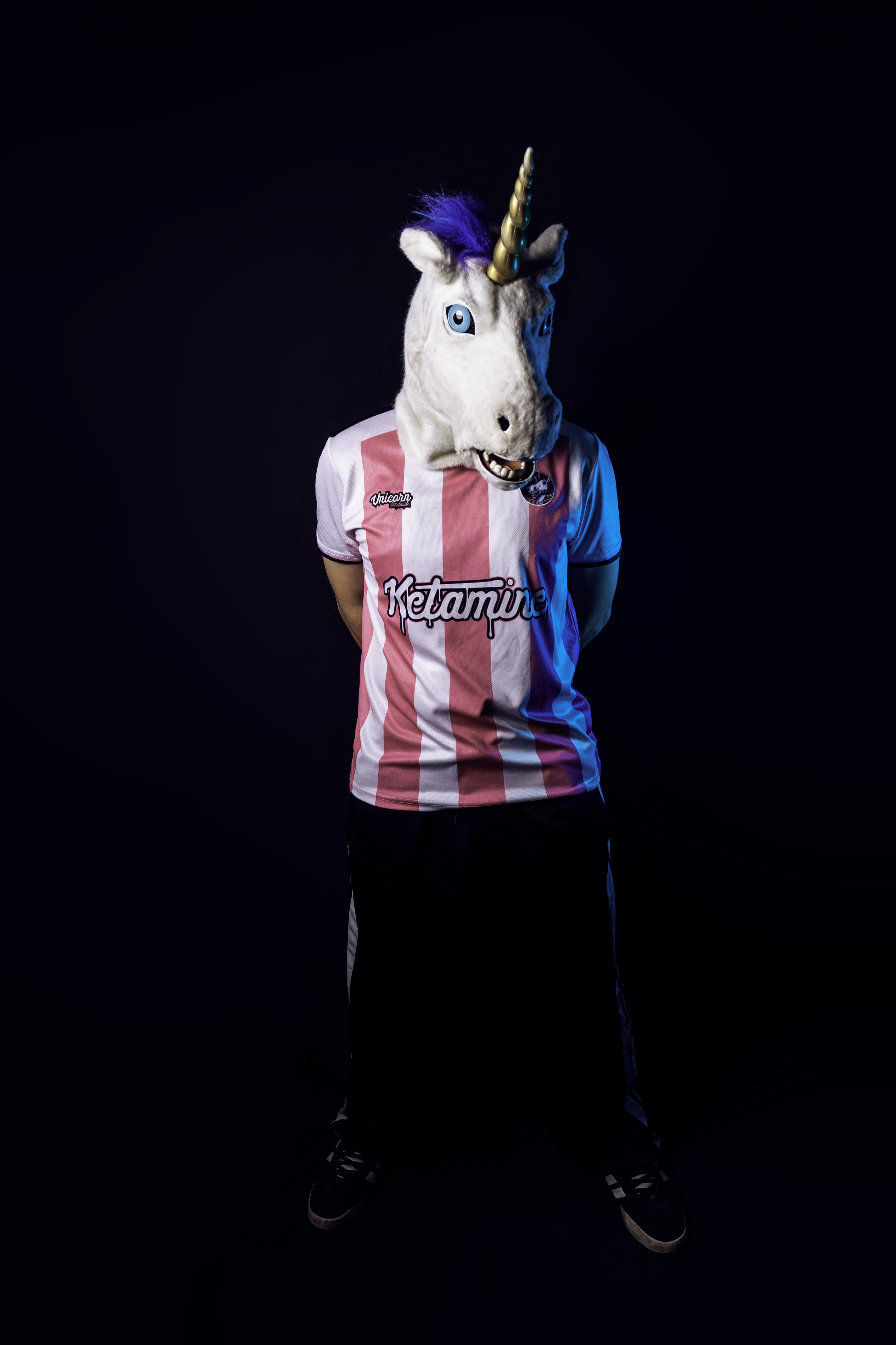 Unicorn on K wearing a pink and white jersey against a dark background